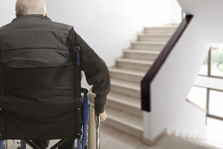 Wheelchair user in front of staircase barrier steve bertasso